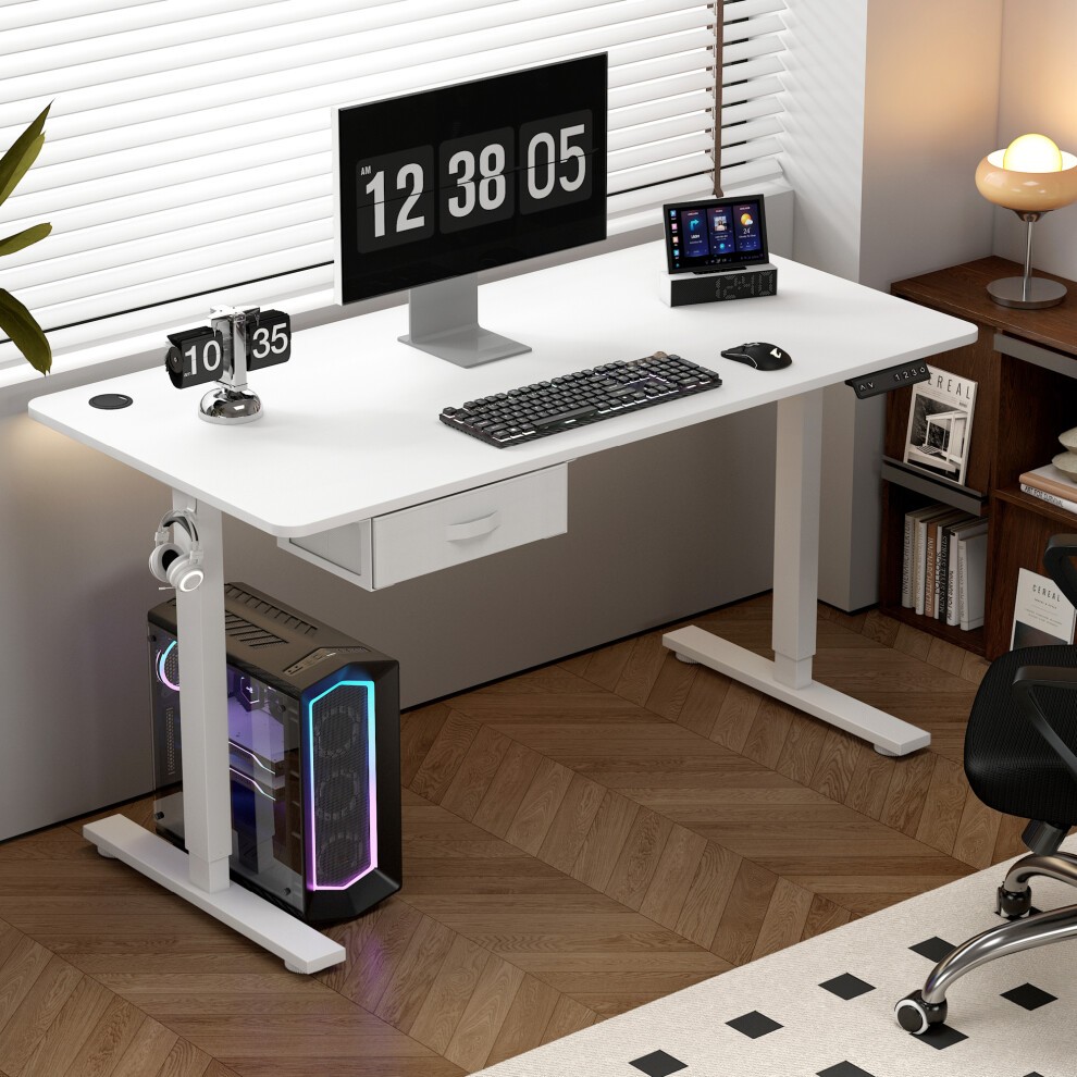 White adjustable electric computer desk with a sleek design, featuring a drawer, monitor, keyboard, and a stylish gaming PC with RGB lighting, set against a modern room backdrop.