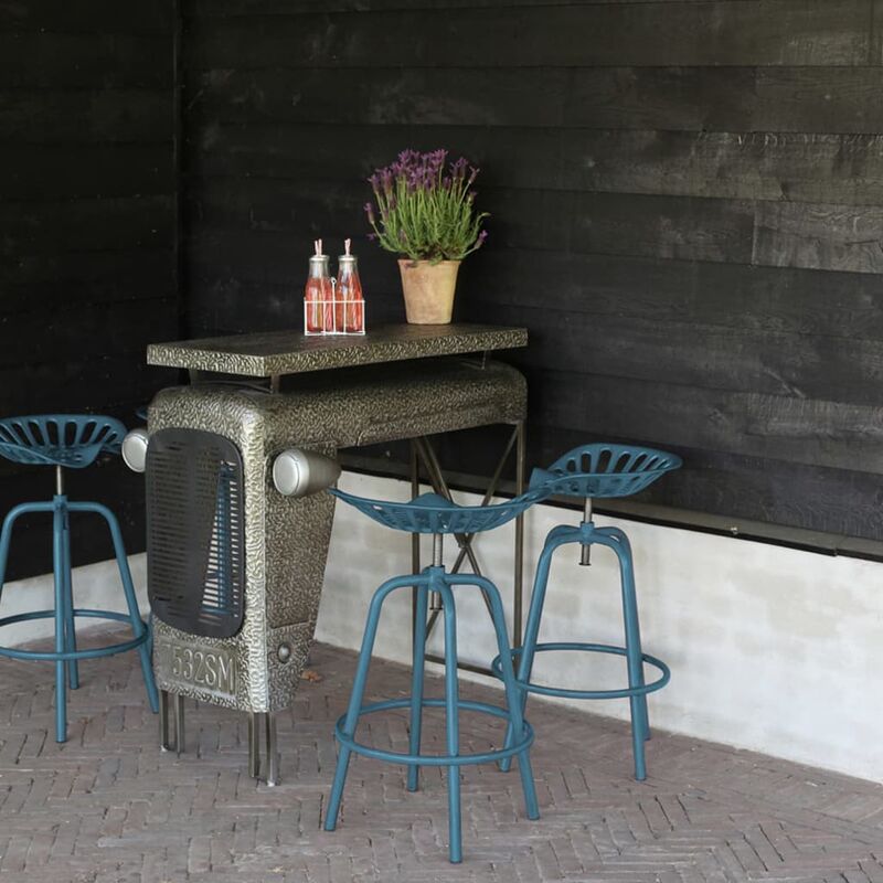 Blue metal tractor chair with a textured finish, featuring a high backrest and circular seat, paired with a matching bar table, set against a dark wooden wall.