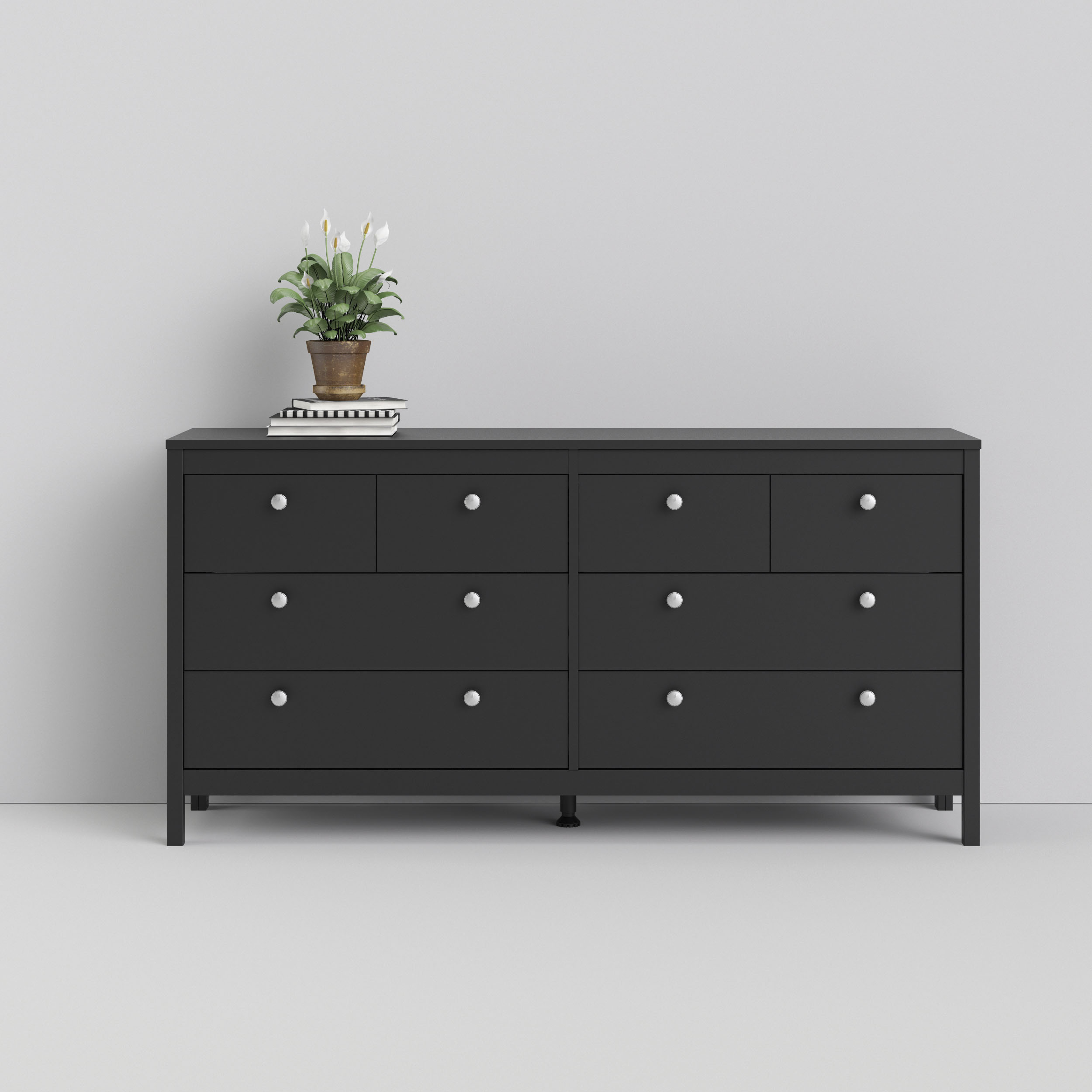Madrid Double Dresser in matte black featuring 8 drawers with round silver knobs, complemented by a small potted plant on top, set against a neutral background.