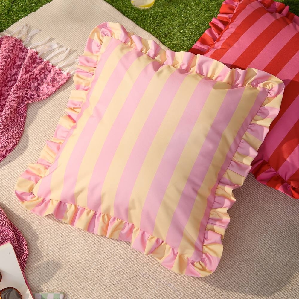 Yellow and pink striped outdoor cushion featuring a ruffled edge, made from durable fabric, perfect for adding a vibrant touch to outdoor seating areas.