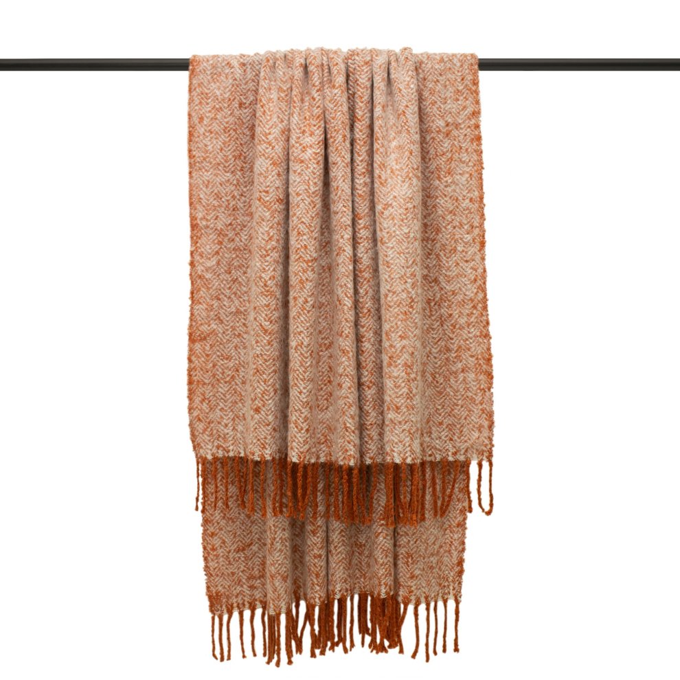 Woven herringbone throw in red and cream, featuring a textured pattern and fringed edges, hanging on a black rod.