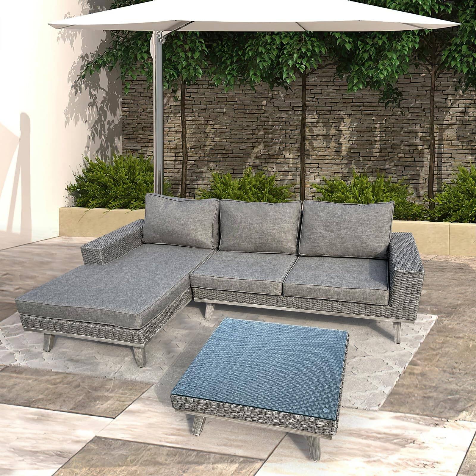Gray aluminum patio furniture set featuring a sectional sofa with padded cushions, a square fire pit table, and a modern design, set against a landscaped outdoor backdrop.