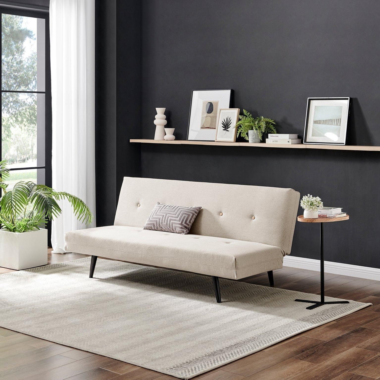 Beige upholstered 2-seater sofa bed with button detailing, sleek black legs, positioned in a modern room with a plant and minimalist decor.