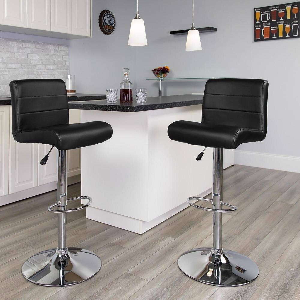 Set of 2 black faux leather barstools with adjustable height, waterfall seat design, and chrome bases, placed near a modern kitchen island with white cabinetry.