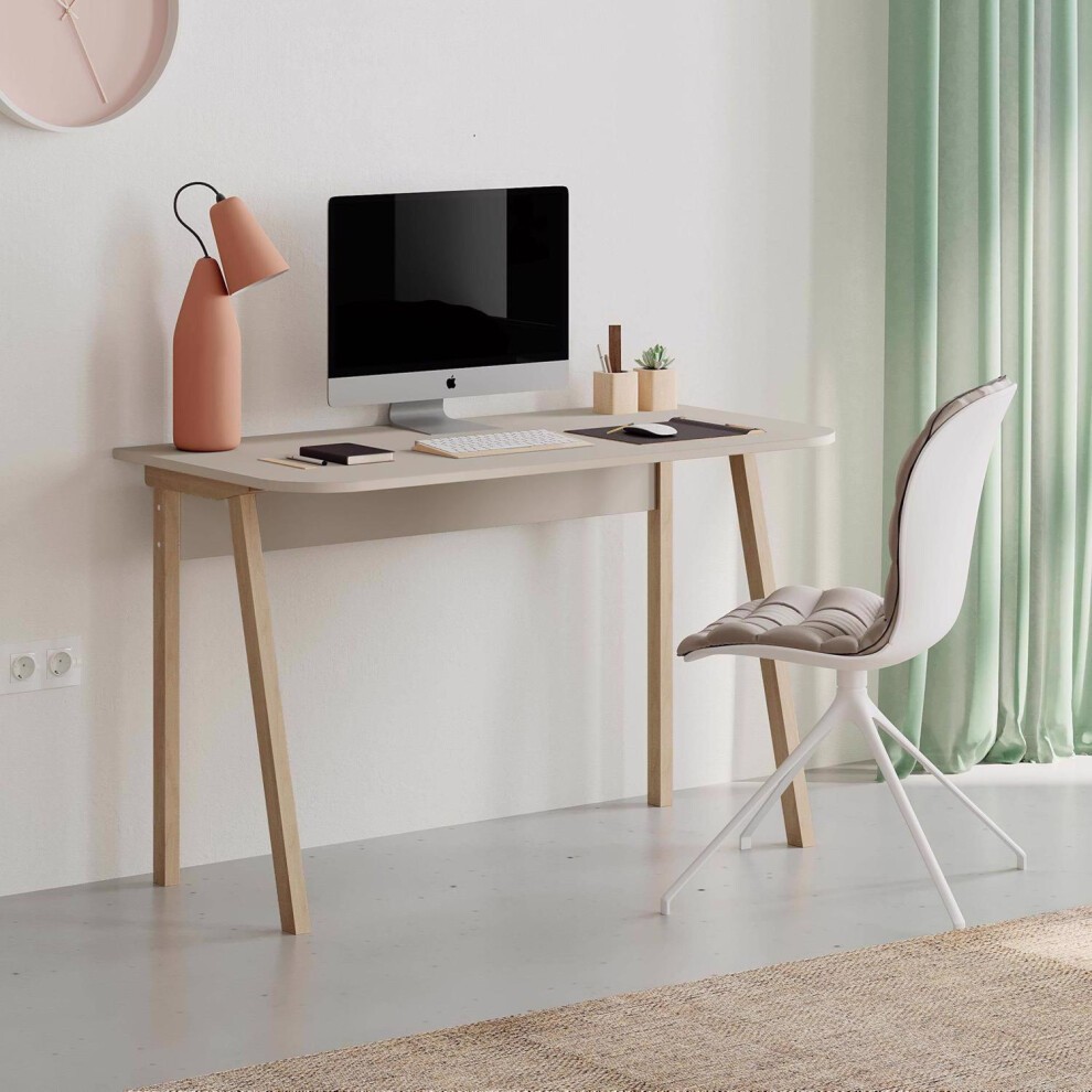 Modern beige sandstone desk with a smooth surface, wooden legs, a sleek computer monitor, a pink lamp, and a stylish white chair against a light wall and green curtains.