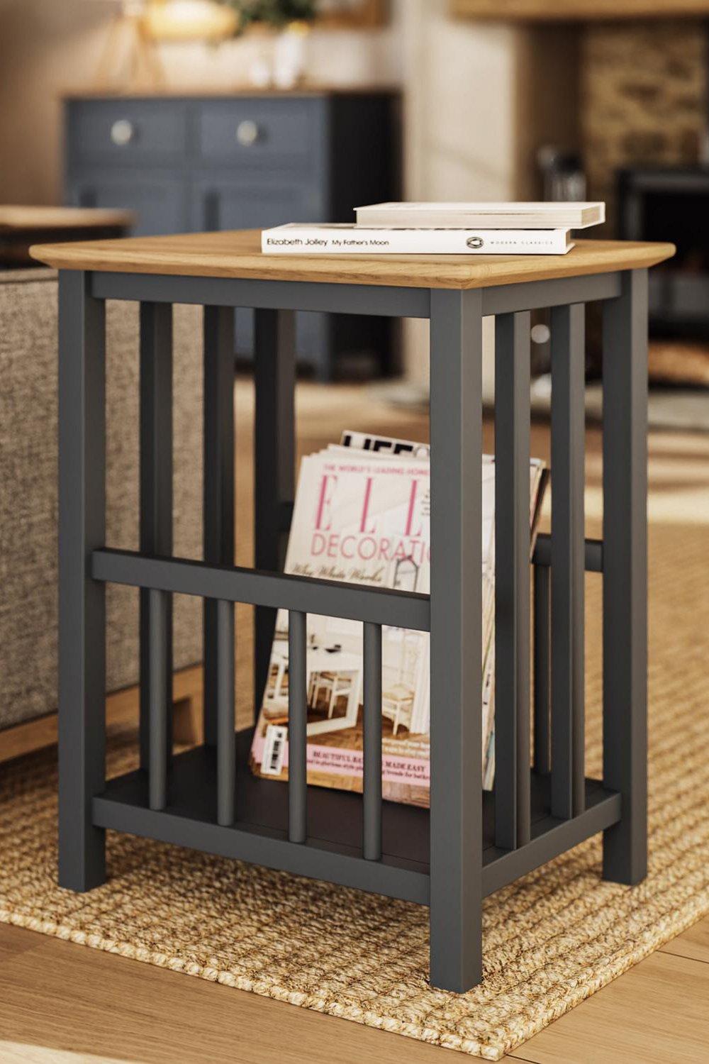 Stylish oak magazine rack table in graphite blue, featuring a dark blue frame, slatted sides, and a natural wood top, perfect for holding magazines and decor.