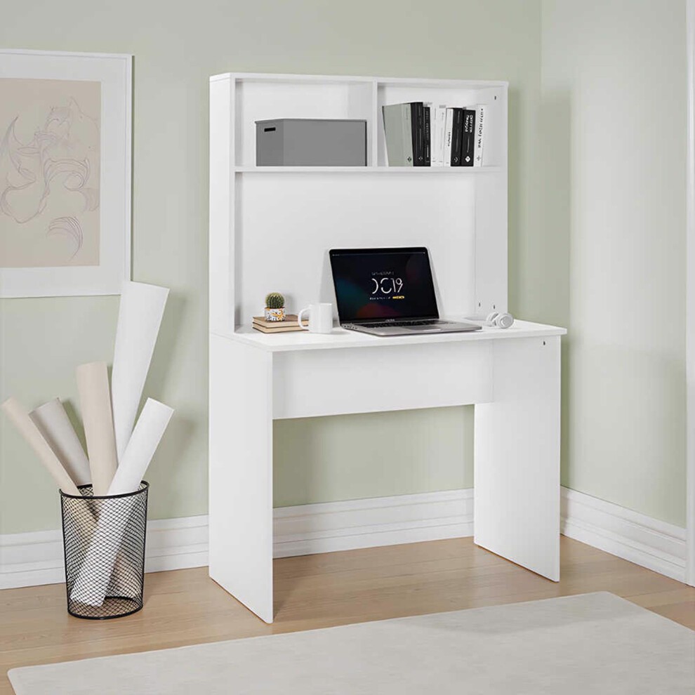 Matt white study desk with a storage hutch, featuring two open shelves, a laptop on the surface, and a minimalist design against a light green wall.