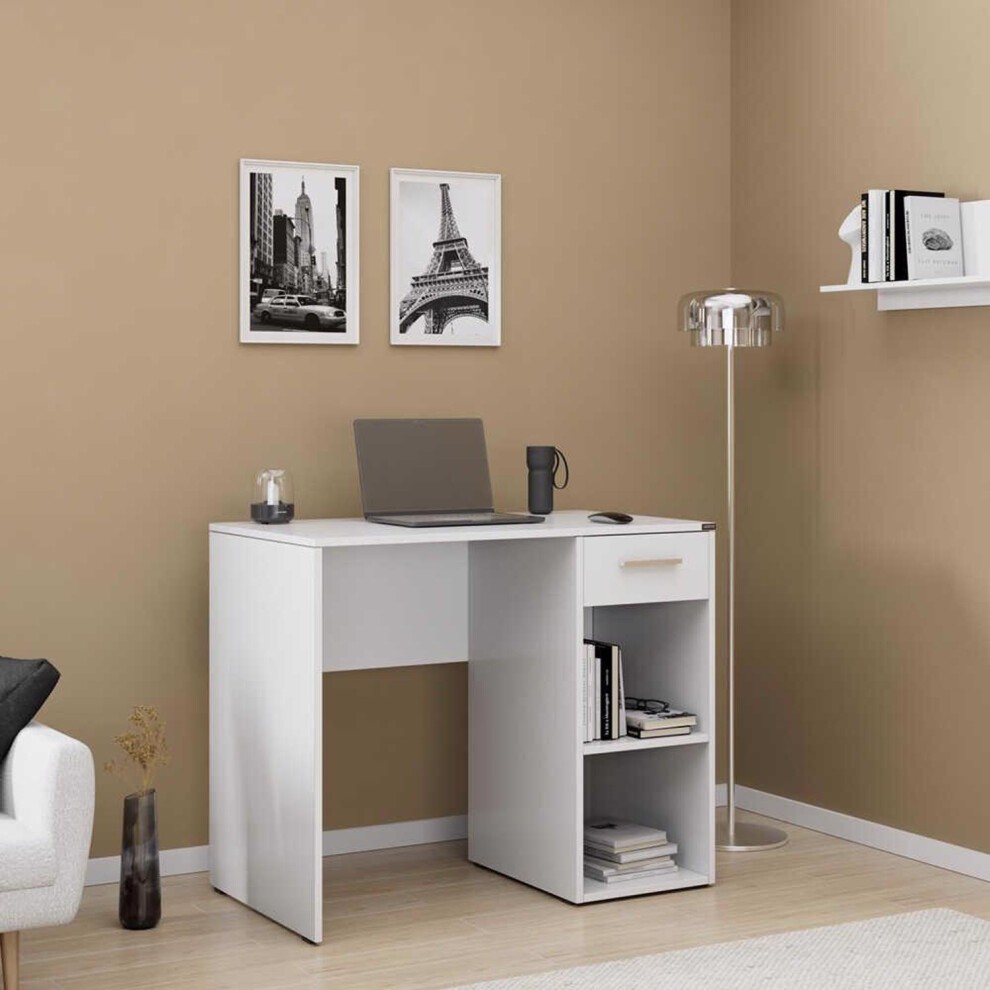 Matt white home office study desk featuring one drawer and two open shelves, accompanied by a laptop, a cup, and framed wall art in a warm-toned room.