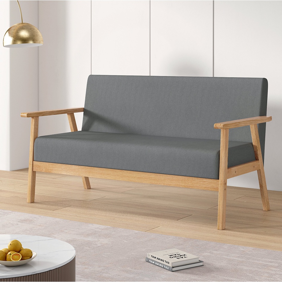 Grey fabric upholstered three-seater sofa with padded seating, wooden armrests, and a minimalist design, set against a light-colored interior.