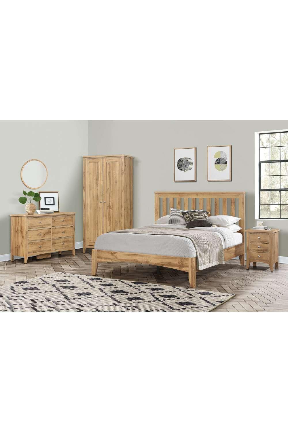 Birlea Hampstead double bed in brown wood with a slatted headboard, complemented by a light grey bedding set, set against a neutral wall and paired with matching wooden furniture.