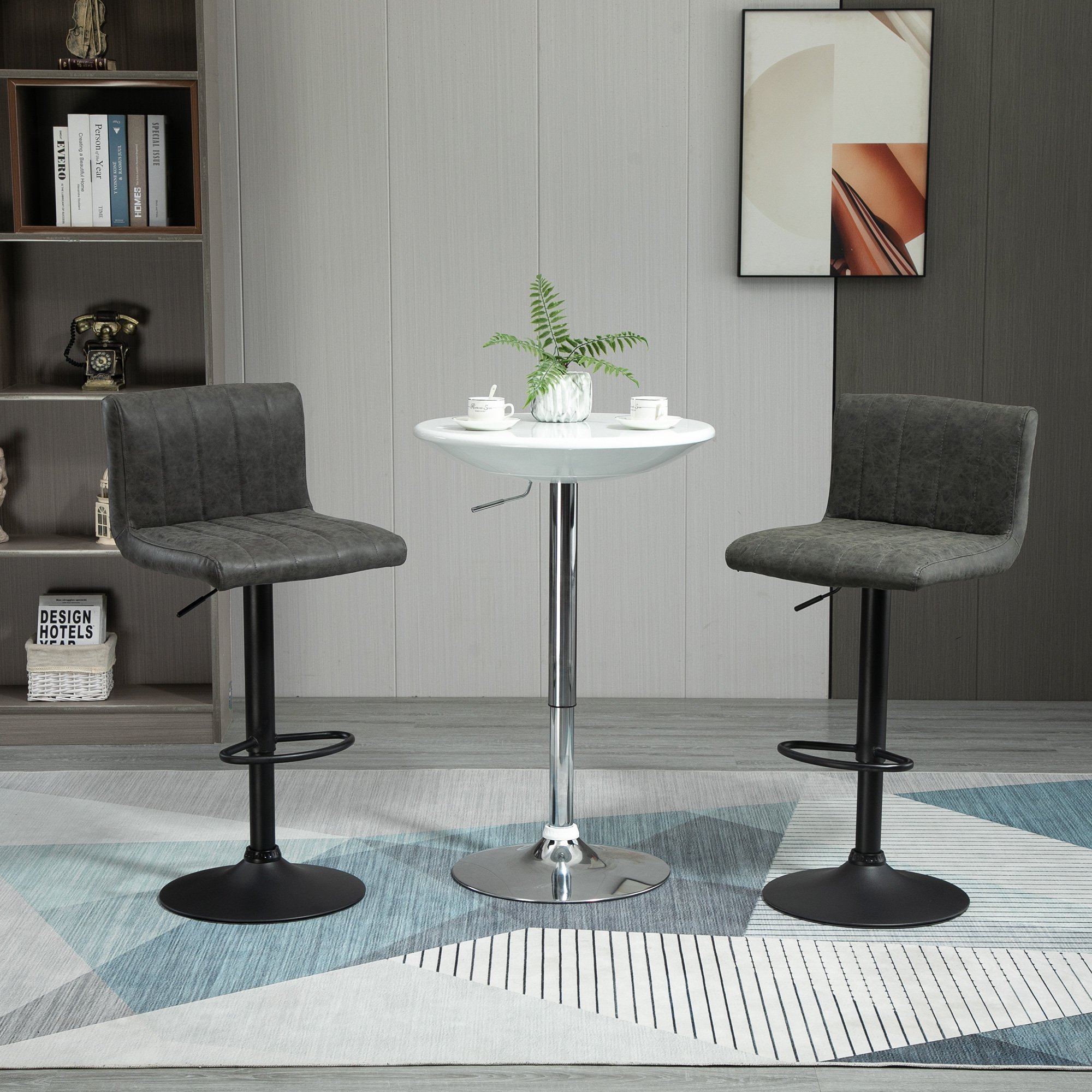 Set of two grey upholstered armless bar stools with a modern design, featuring a chrome base and adjustable height, placed beside a small round white table in a stylish interior.