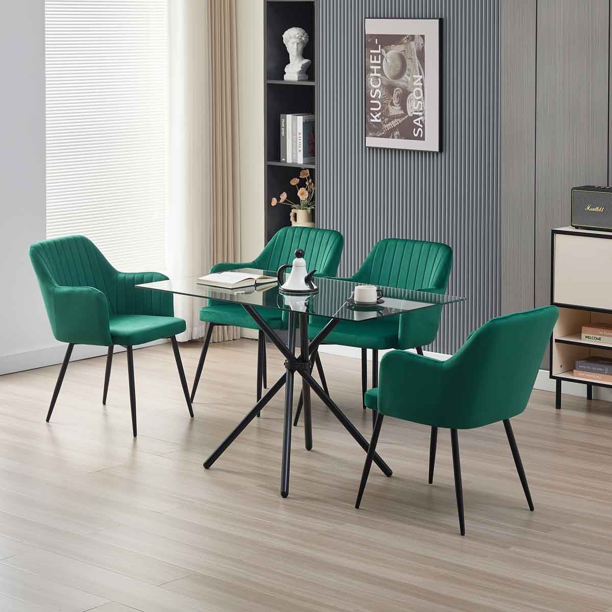Miami dining table featuring a sleek glass top and black metal legs, surrounded by four green velvet Charlotte chairs with ribbed detailing.
