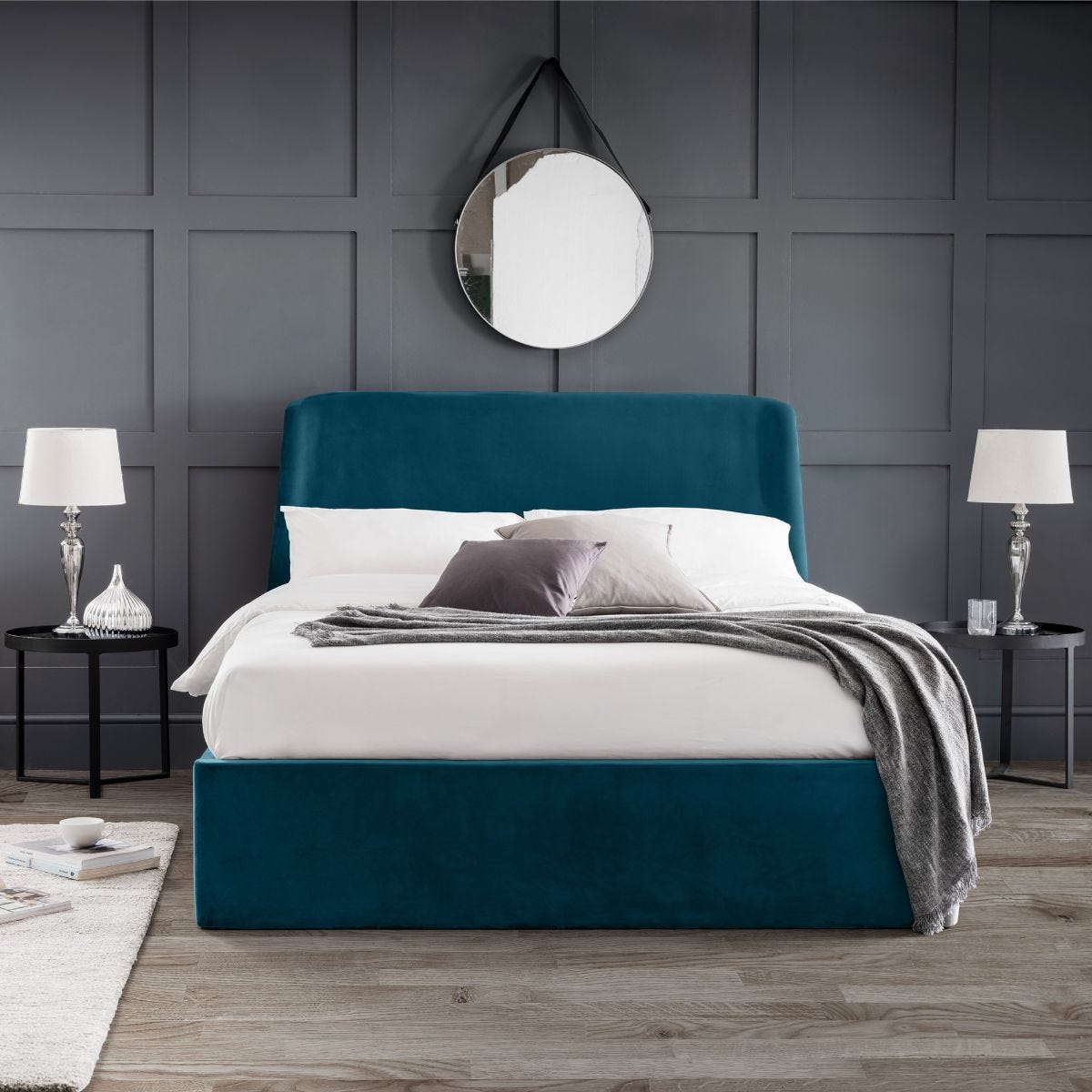 Teal velvet storage ottoman bed with a sleek headboard, featuring a double size (135cm), complemented by white bedding and decorative pillows in a modern bedroom setting.