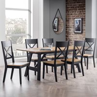 Stylish dining set featuring a rectangular wooden table with a light oak top and black legs, accompanied by six black and oak cross-back chairs against a brick wall.