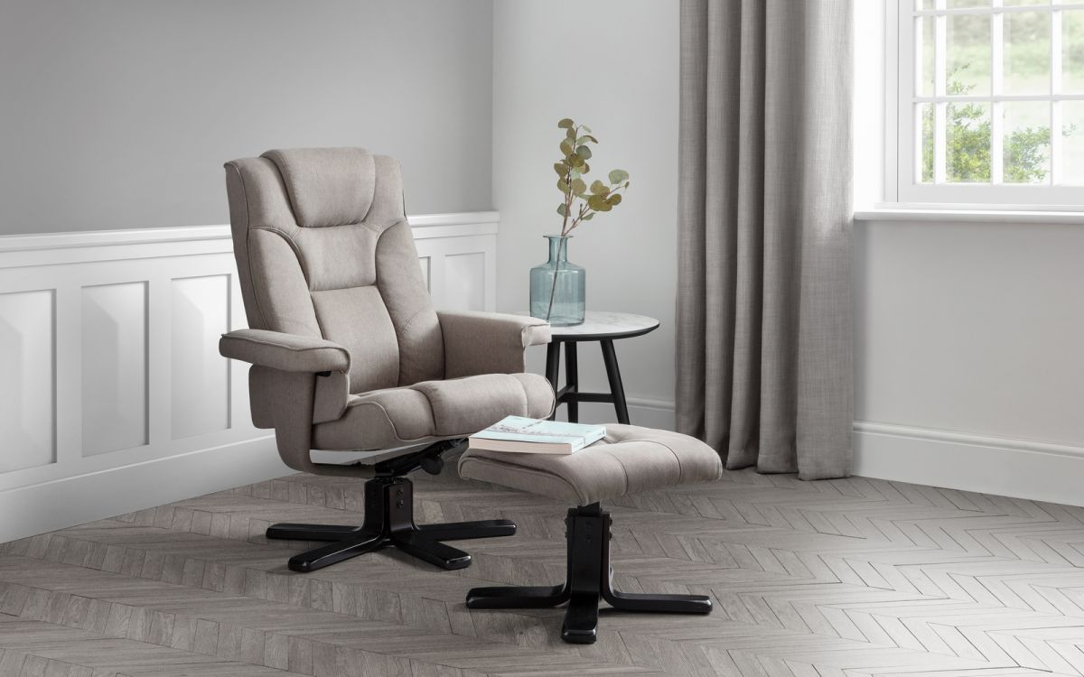 Grey swivel recliner chair with matching stool, upholstered in soft fabric, featuring a padded backrest and armrests, set against a light grey wall and wooden floor.