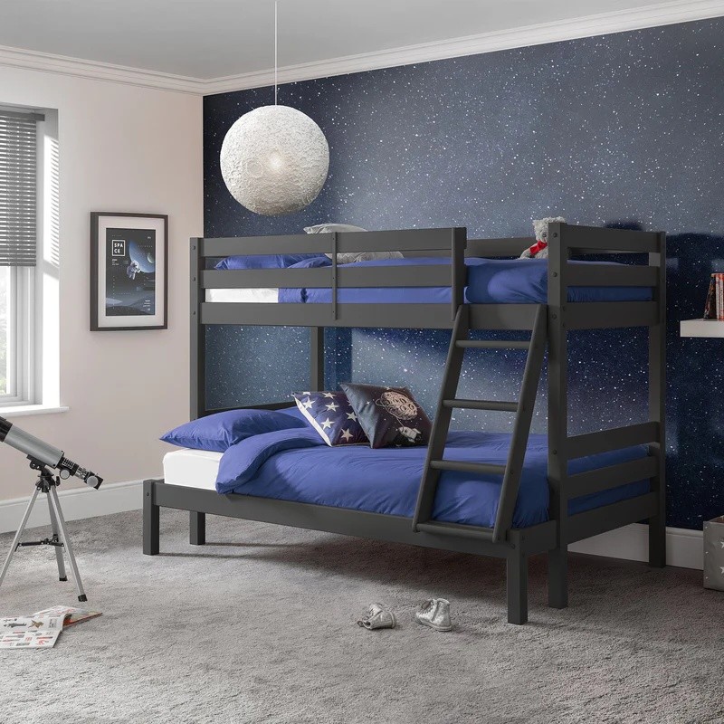 Julian Bowen Merlin Triple Sleeper Bunk Bed in anthracite, featuring a sturdy wooden frame, two upper bunks, a lower double bed, and blue bedding, set against a starry wall.