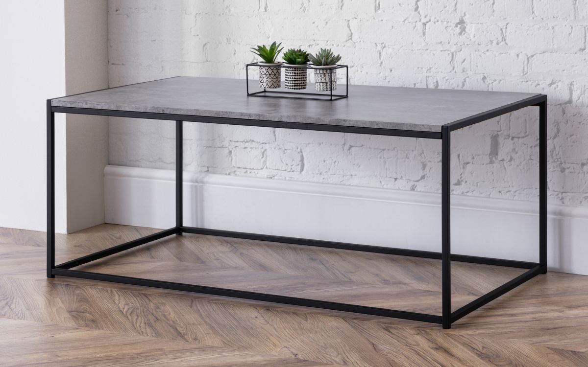 Concrete coffee table with a sleek black metal frame, featuring a minimalist design and topped with small potted plants in decorative containers.