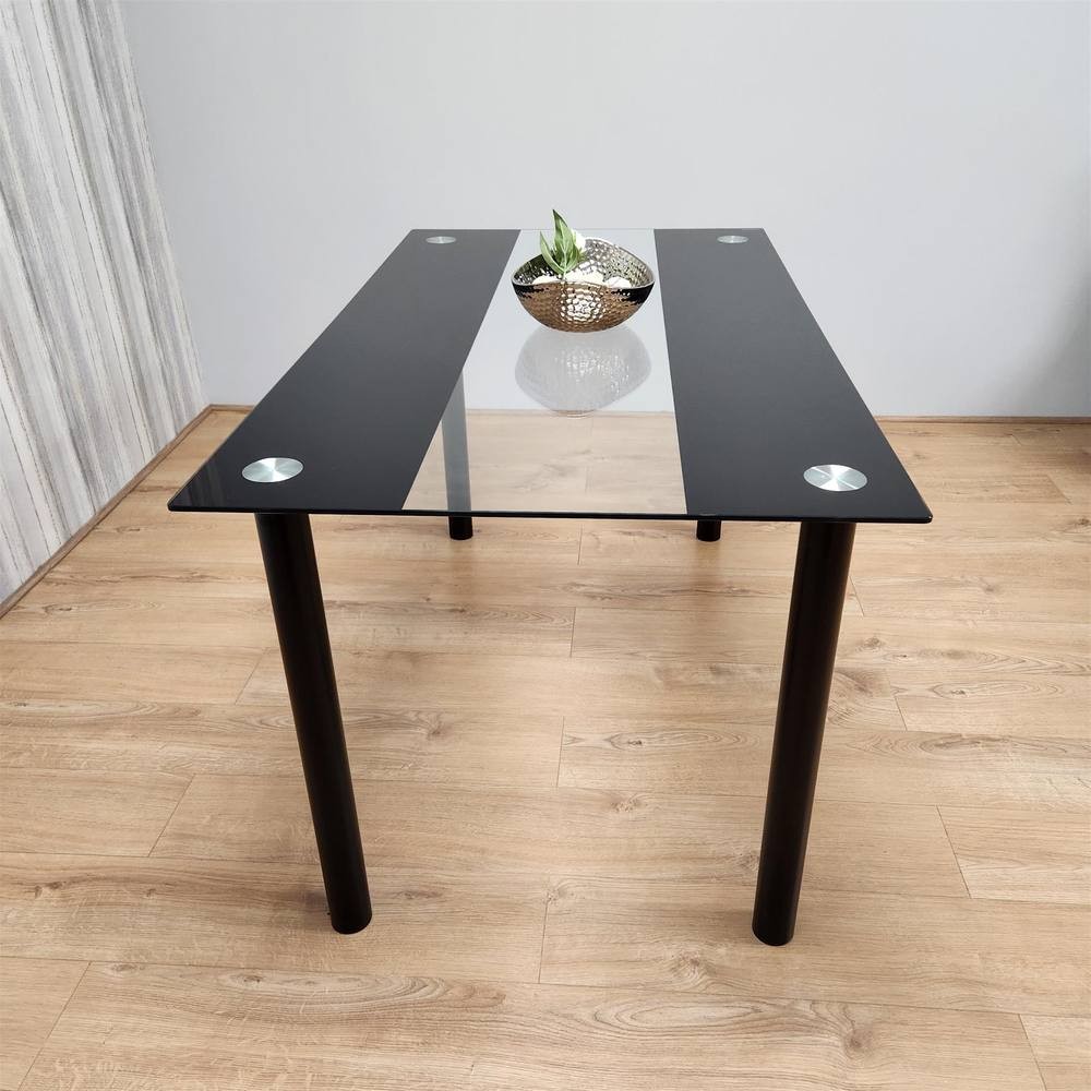 Black glass dining table with a sleek design, featuring four seats, metal accents, and a minimalist look, set on a wooden floor with a decorative bowl on top.