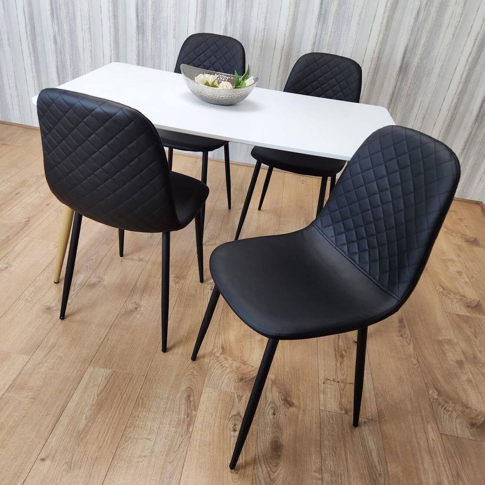 KOSY KOALA dining table set features a sleek white table with four black quilted chairs, set against a light wooden floor and a textured wall, ideal for dining rooms or kitchens.