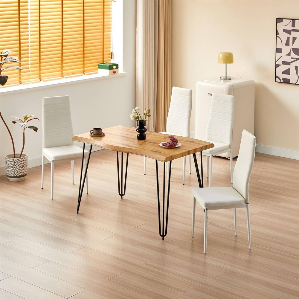 Kosy Koala dining table in brown wood with four white upholstered chairs, featuring sleek metal legs, set in a bright, modern kitchen with a potted plant and lamp.