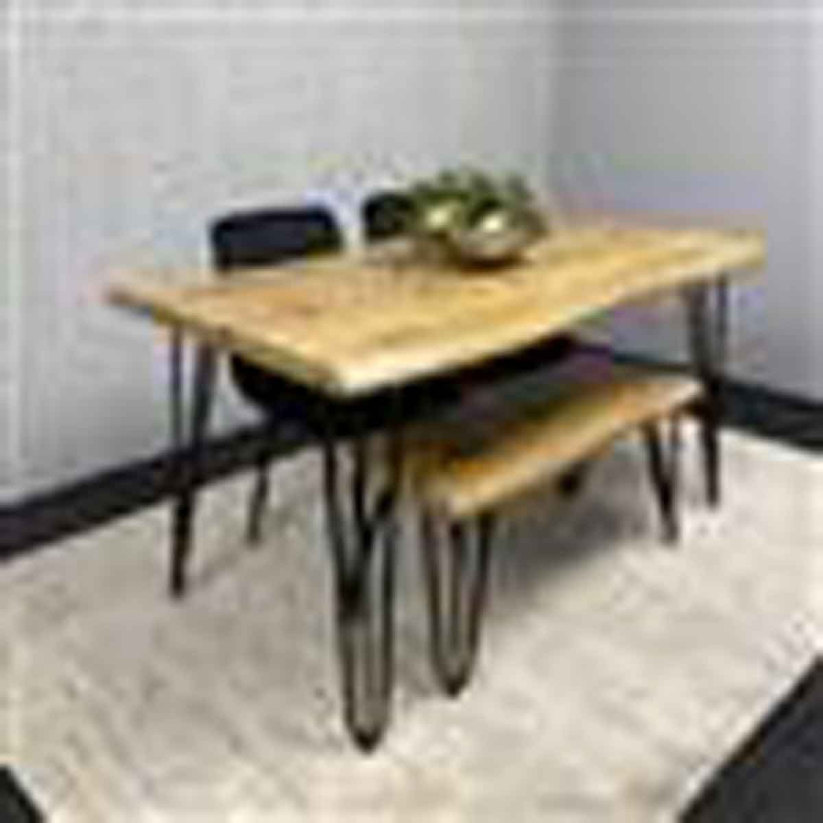 Modern dining table set featuring a brown wooden table with black metal legs, complemented by two black velvet chairs and a matching bench, set on a light rug.