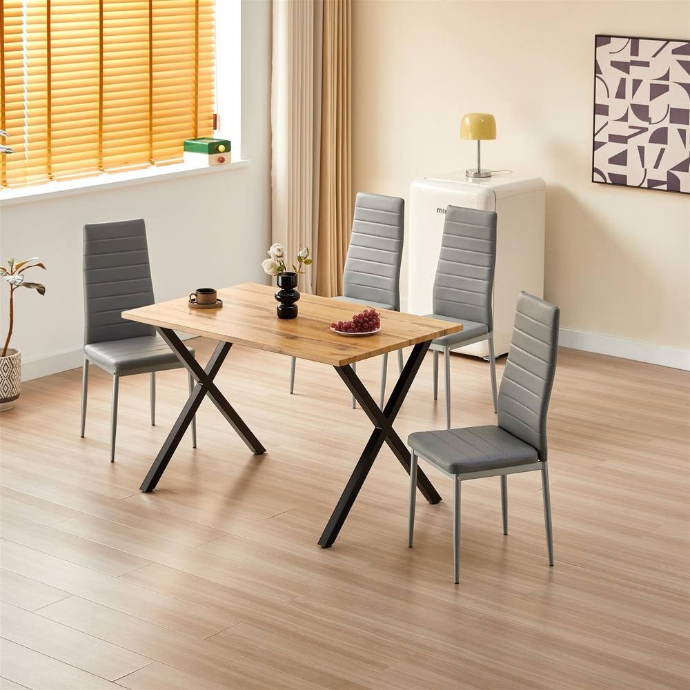 Kosy Koala wooden dining table in brown with a light wood finish, accompanied by four grey leather chairs featuring vertical stitching and sleek metal legs.
