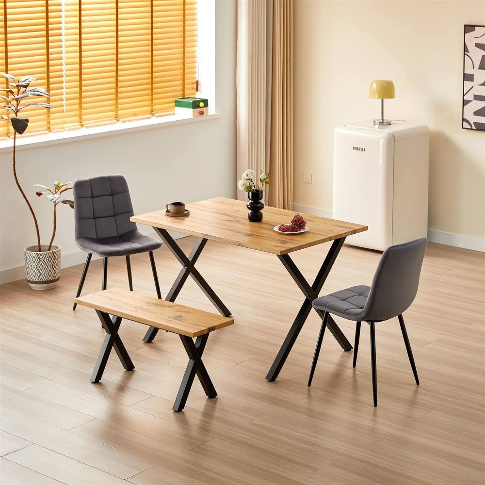 Kosy Koala wooden dining table in brown with two grey velvet chairs and a matching bench, set in a modern kitchen room with natural light and minimalistic decor.