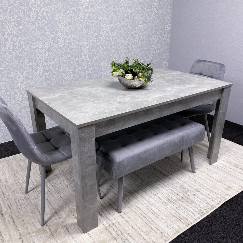 Kosy Koala wooden dining table in brown with two grey velvet padded benches, featuring a modern design and a stylish centerpiece plant arrangement.