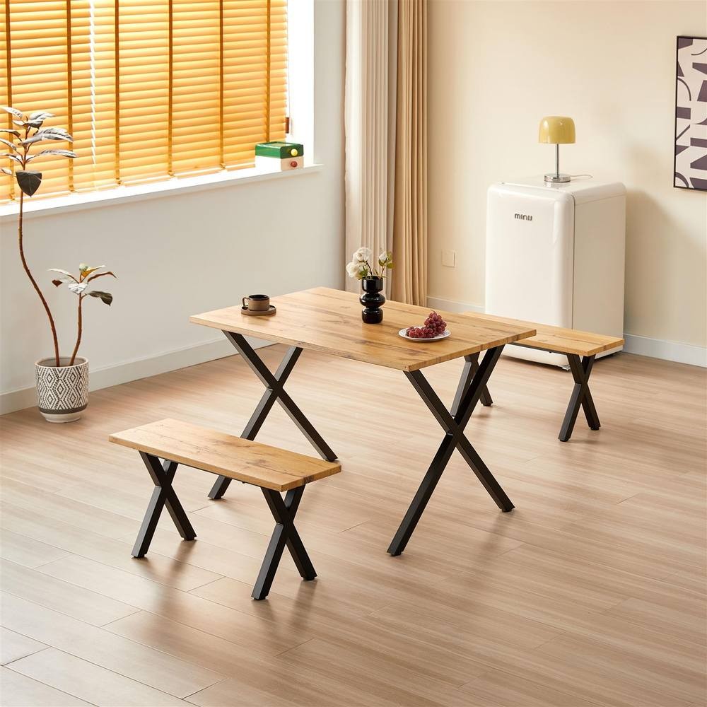 Brown wooden dining table with two matching benches, featuring black metal legs, set in a bright room with natural light and minimal decor.
