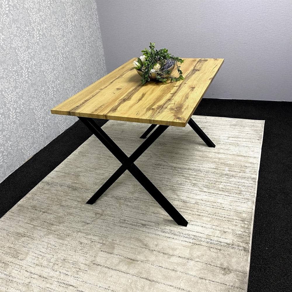 Brown wooden dining table with a textured surface, supported by sleek black metal legs, placed on a light-colored rug with a decorative plant centerpiece.