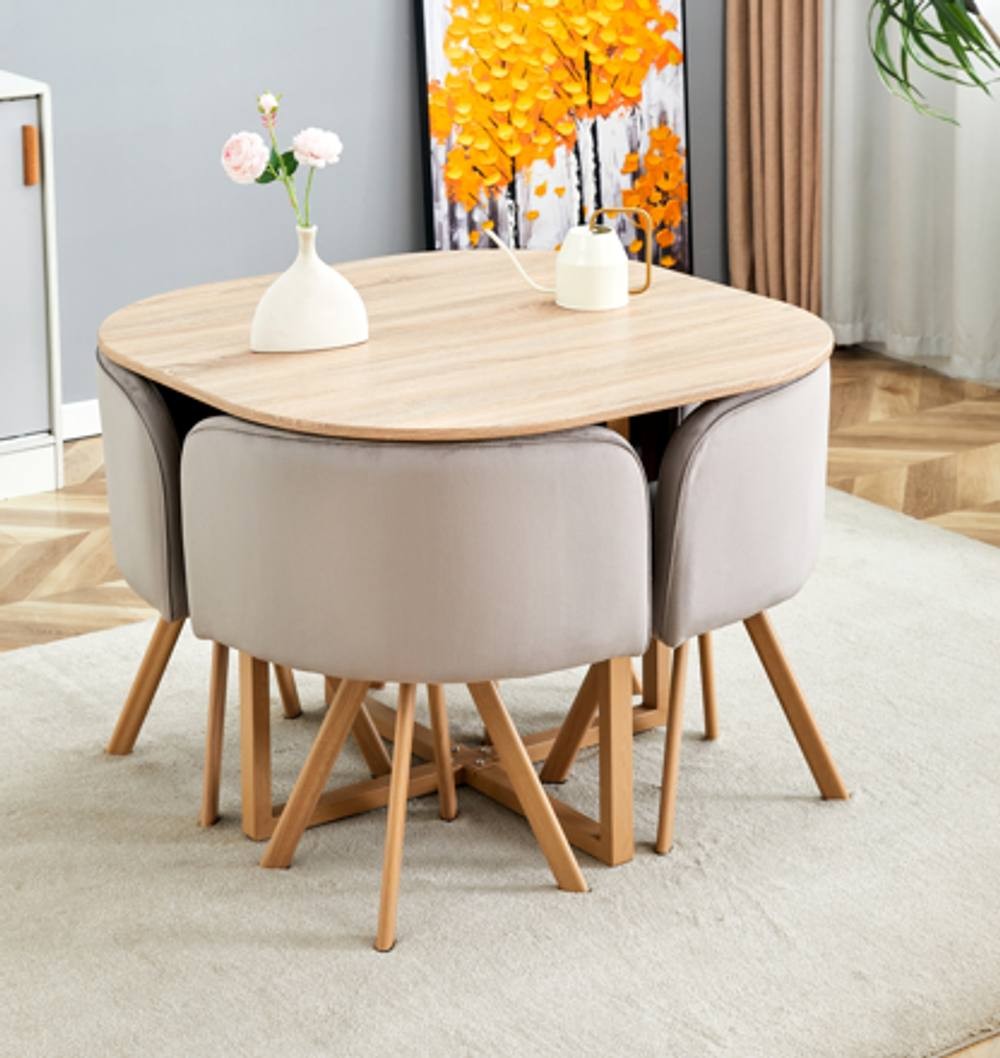 Brown space-saving dining table with a smooth wooden top, surrounded by four beige velvet chairs, all supported by wooden legs, set on a light-colored rug.