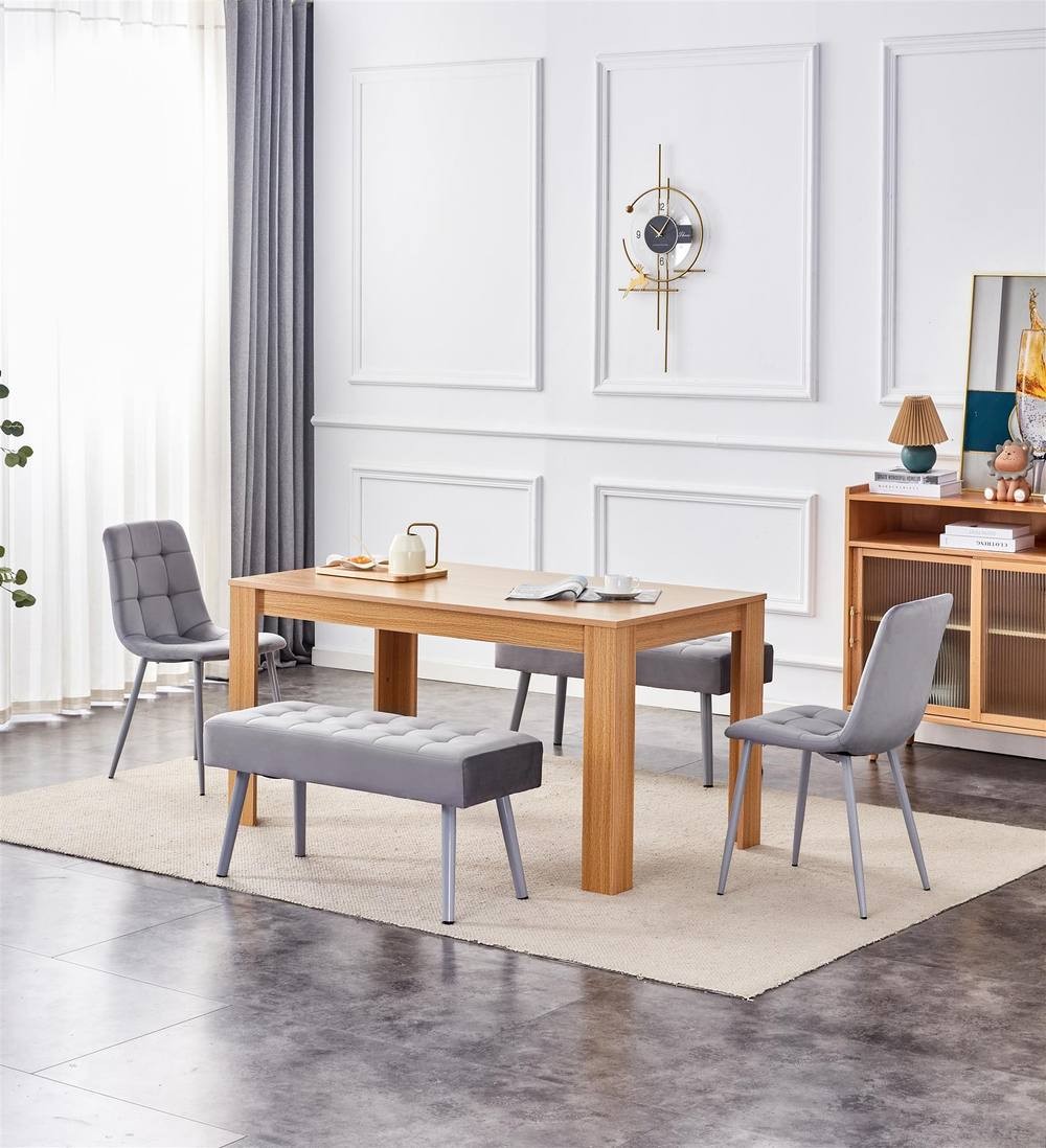 Dining table in oak effect wood with two grey velvet chairs and two grey benches, set in a bright room with light curtains and modern decor. Size: 140cm x 80cm.