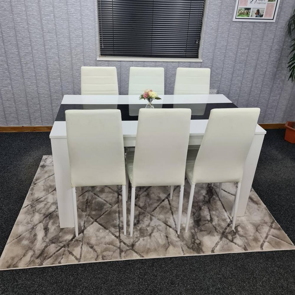 White KOSY KOALA dining table set featuring a sleek rectangular table with a black center stripe and six matching white chairs on a patterned rug.