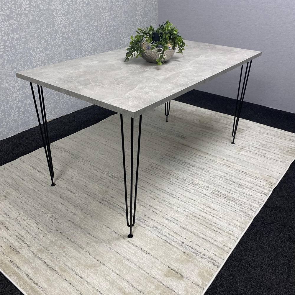 Modern grey rectangular dining table with hairpin legs, featuring a sleek surface and compact design, complemented by a decorative plant in a bowl on top.