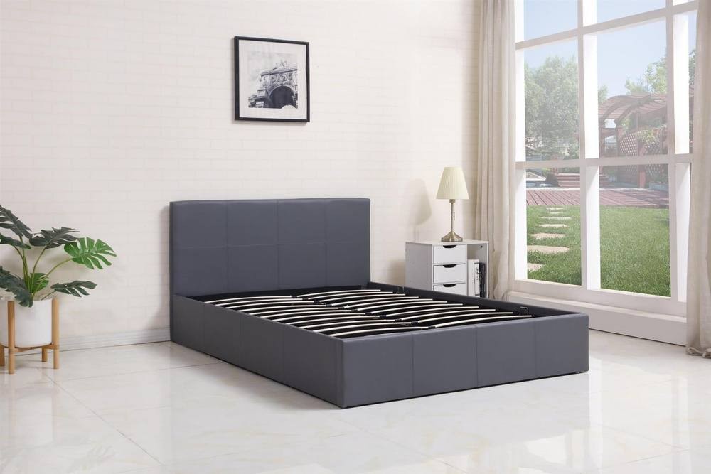 Grey leather ottoman bed with gas lift storage, 4ft small double size, featuring a sleek headboard and pine wood slats, set in a bright room with large windows.