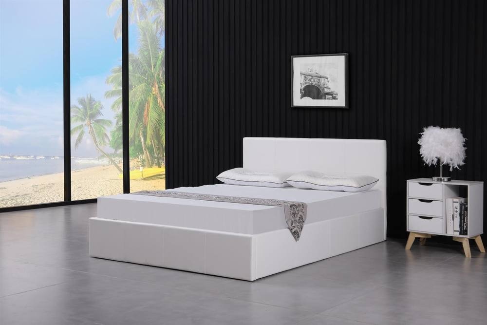 White leather ottoman bed with gas lift storage, featuring a small double size and a simple design, accompanied by a mattress, set against a modern interior with large windows.