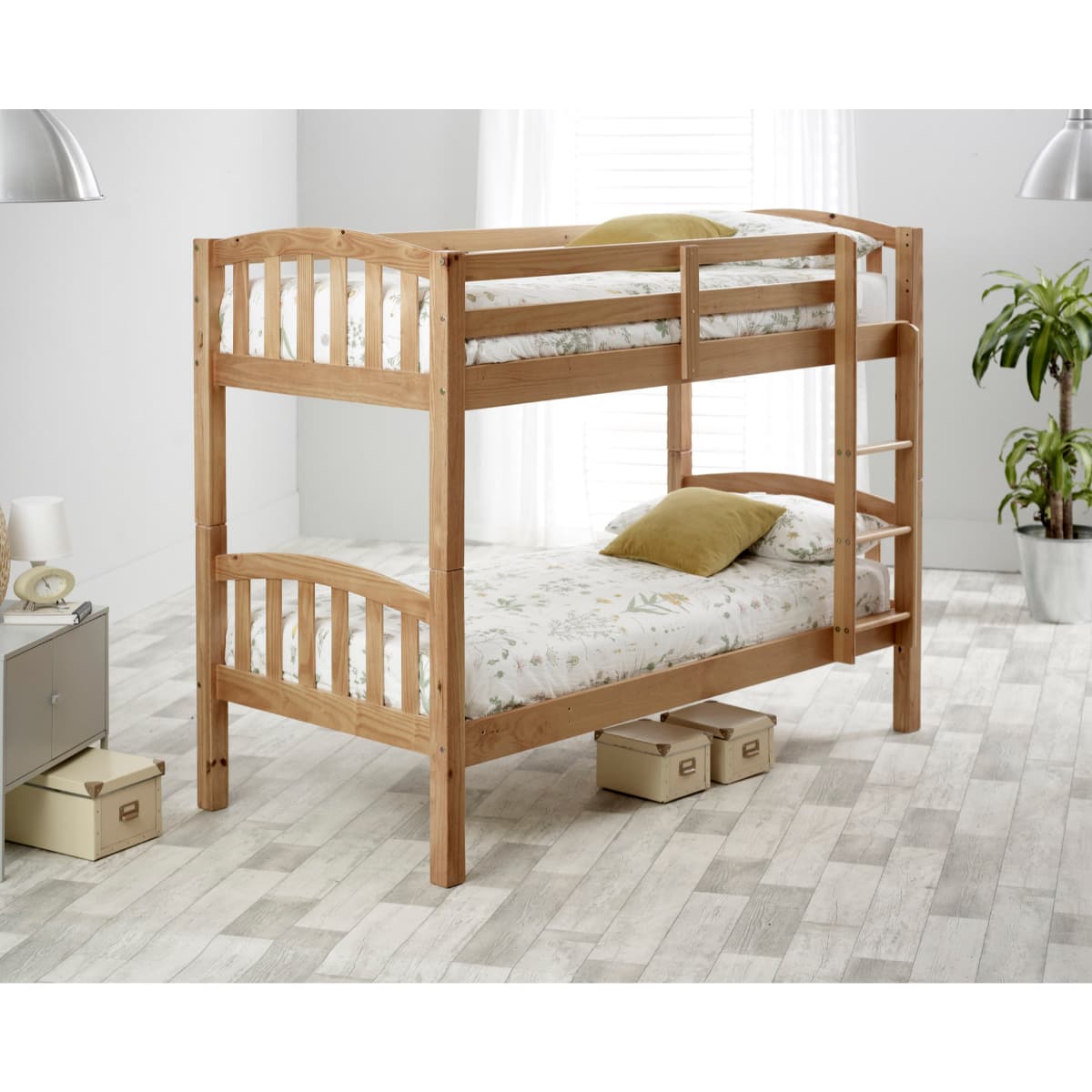 Brown pine bunk bed with a natural finish, featuring a slatted design, two spring mattresses with floral patterns, and a sturdy ladder, set in a bright, modern room.