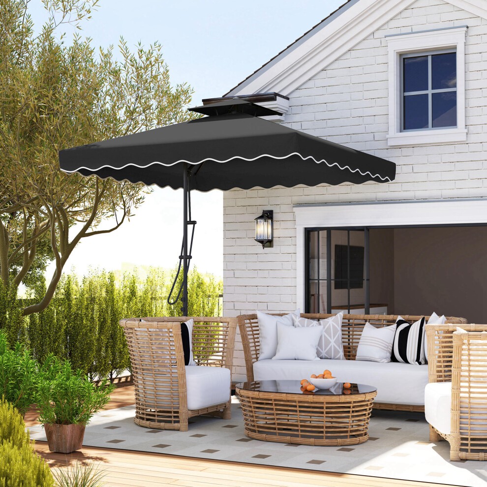 Black cantilever garden parasol umbrella with a cross base, featuring a scalloped edge, positioned over a wicker seating area and a round coffee table in a sunny outdoor setting.