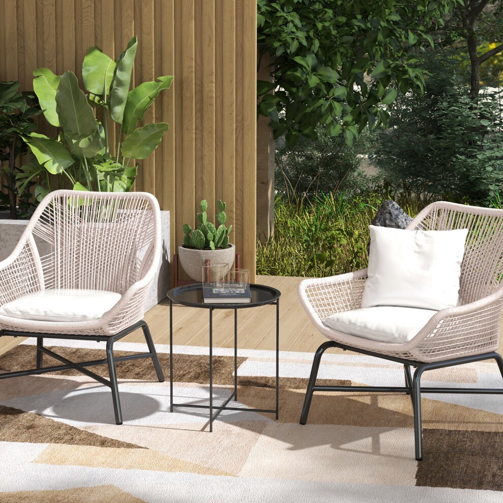 Round black garden table with a removable tray, featuring a sleek metal frame, positioned between two stylish chairs on a patio surrounded by greenery.