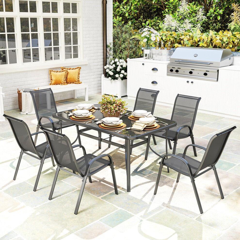 Seven-piece garden dining set featuring a grey metal frame, a rectangular glass-top table, and six matching chairs with mesh backs, set in a vibrant outdoor space.