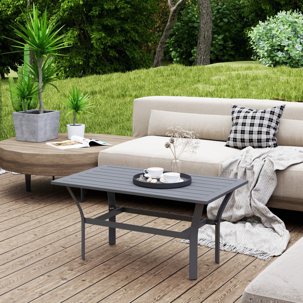 Dark grey metal garden coffee table with a slatted tabletop, positioned on a wooden deck, accompanied by a tray of coffee cups and a decorative plant.