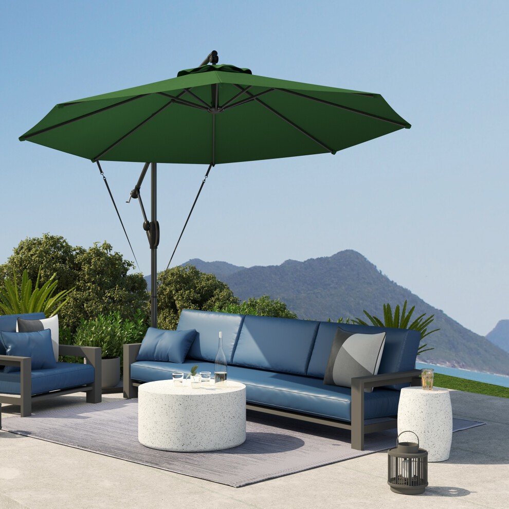 Green cantilever banana parasol with a UPF50+ rating, featuring a sturdy metal frame and a protective cover, shading a modern outdoor seating area with blue cushions and a round table.