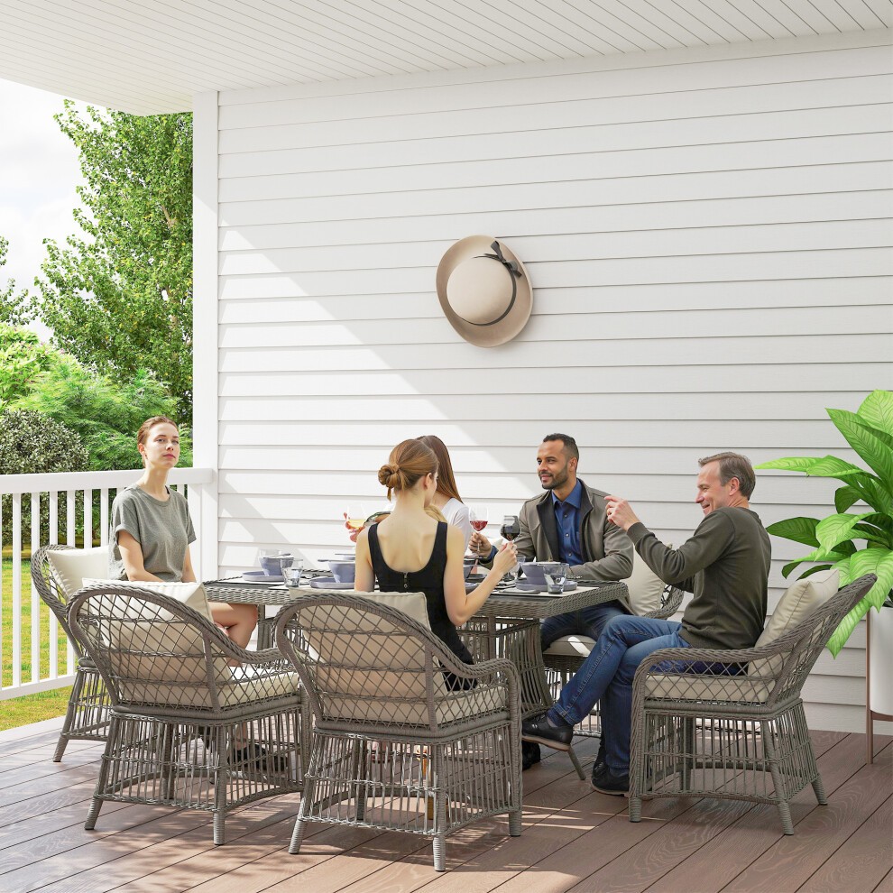 Stylish 6-seater rattan dining set with seat back cushions, featuring an aluminum frame, set on a wooden deck with greenery and a hat on the wall in the background.