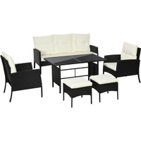 White rattan garden furniture set with 2 armchairs, 2 footstools, and a table, featuring plush white cushions.