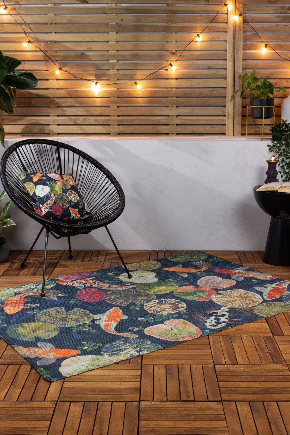 Tropical rug featuring colorful koi fish and lily pads on a midnight blue background, made from UV and weatherproof material, measuring 120cm x 170cm.
