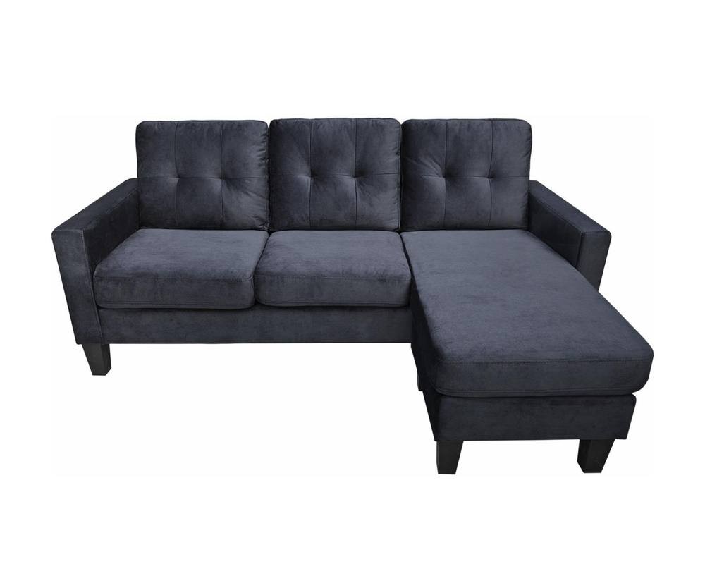L-shaped black velvet sectional sofa featuring a reversible design, tufted back cushions, and a matching ottoman, ideal for modern living spaces.