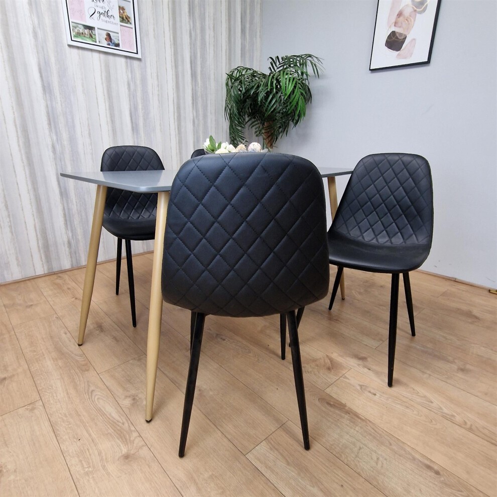 KOSY KOALA grey wooden rectangular table with four black gem-patterned chairs featuring diamond stitching and wooden legs in a modern interior setting.