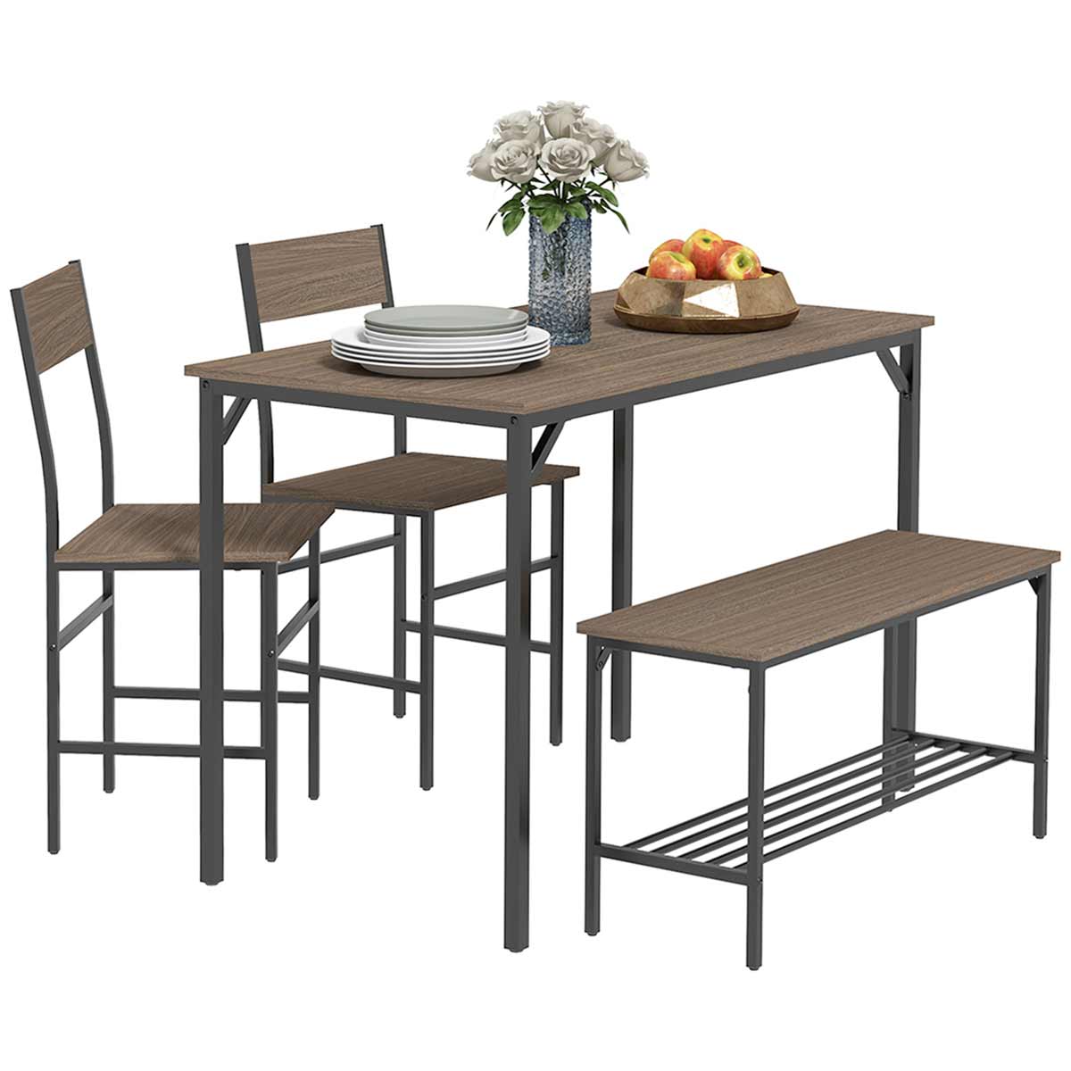 Grey industrial-style dining table set featuring a rectangular table, two high-backed chairs, and a bench, all with a wood-like finish and metal frames, complemented by decorative flowers and fruit.