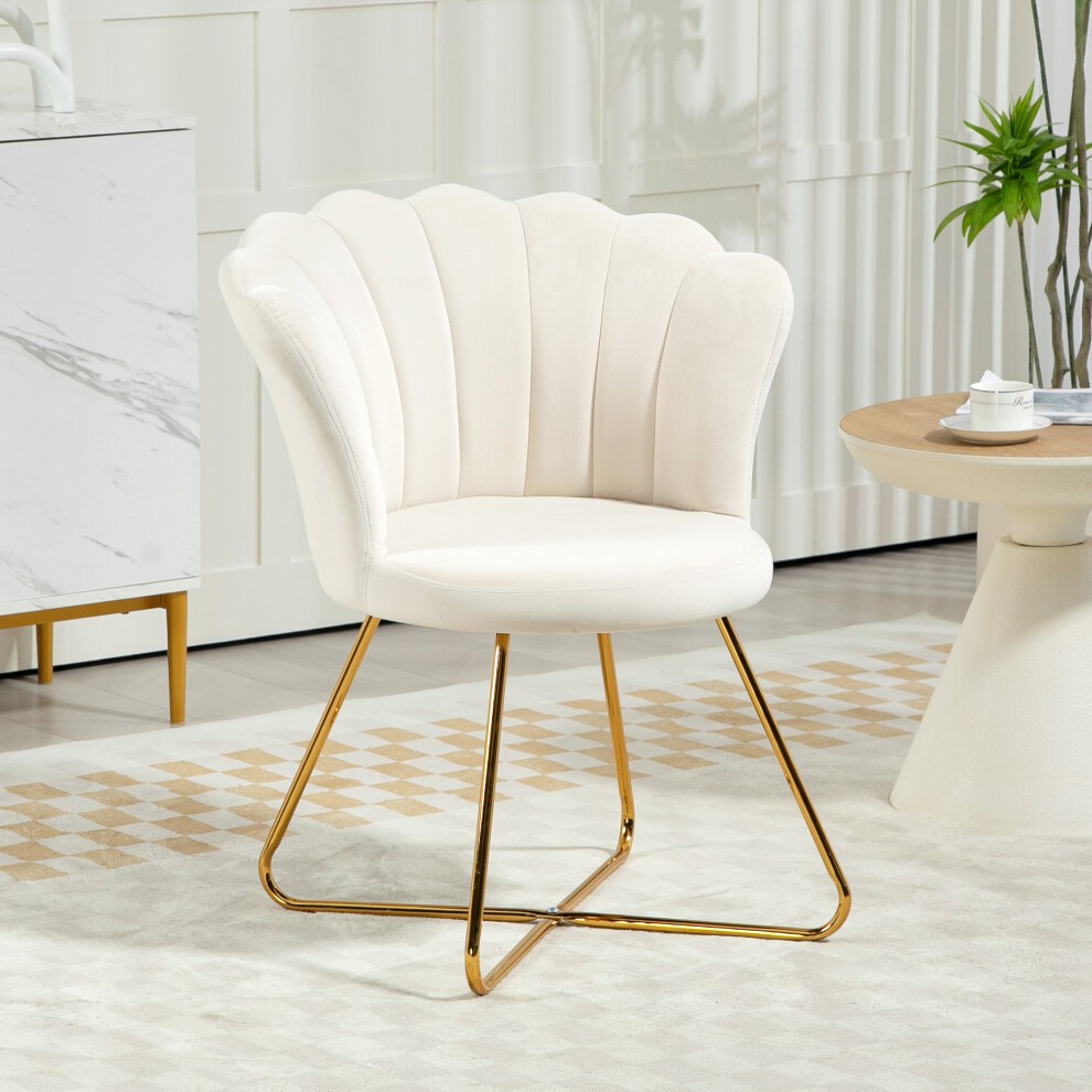 Cream velvet accent chair with a lotus-shaped backrest, supported by sleek gold steel legs, set in a modern room with a light-colored rug and wooden table.