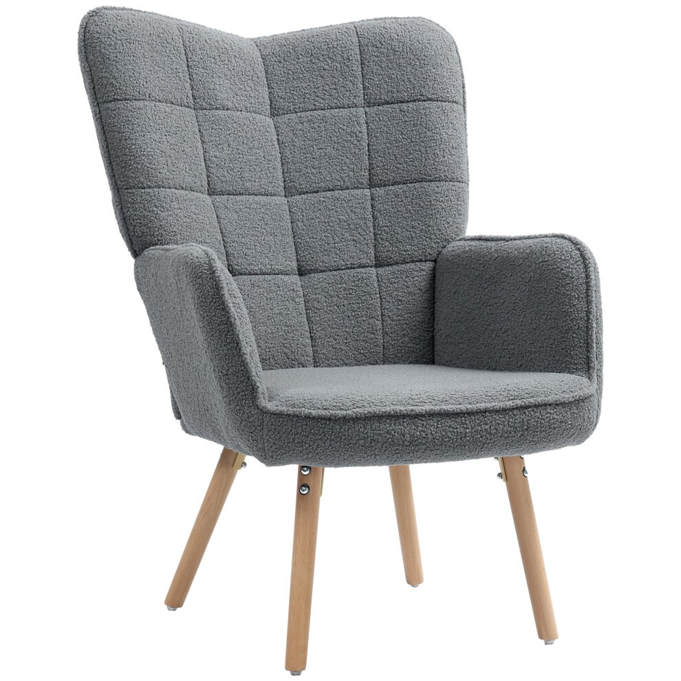 Upholstered wingback armchair in dark grey with tufted fabric, padded seat, and wooden legs, offering a modern and cozy design suitable for any living space.